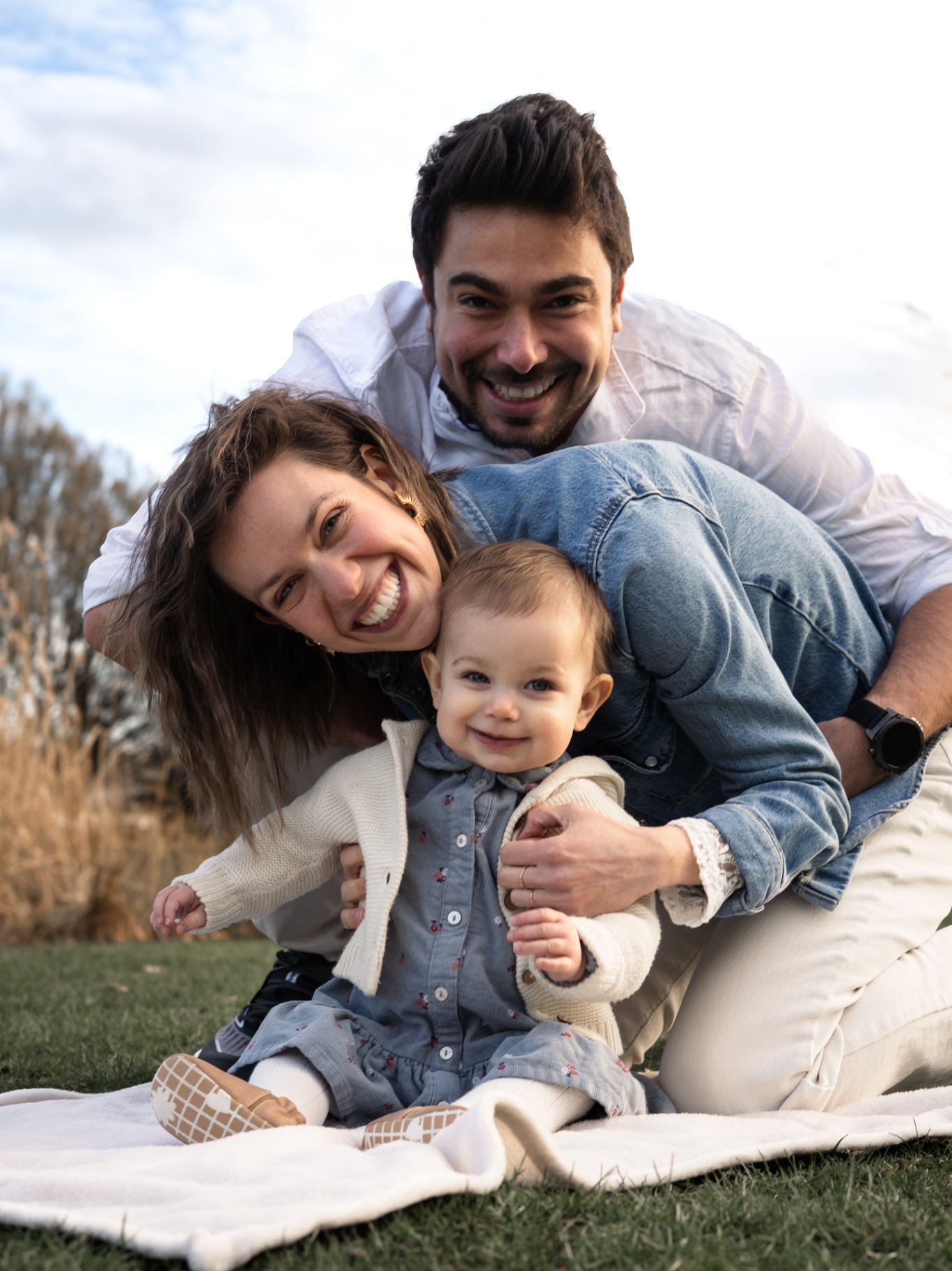 Famille riant ensemble sur l'herbe