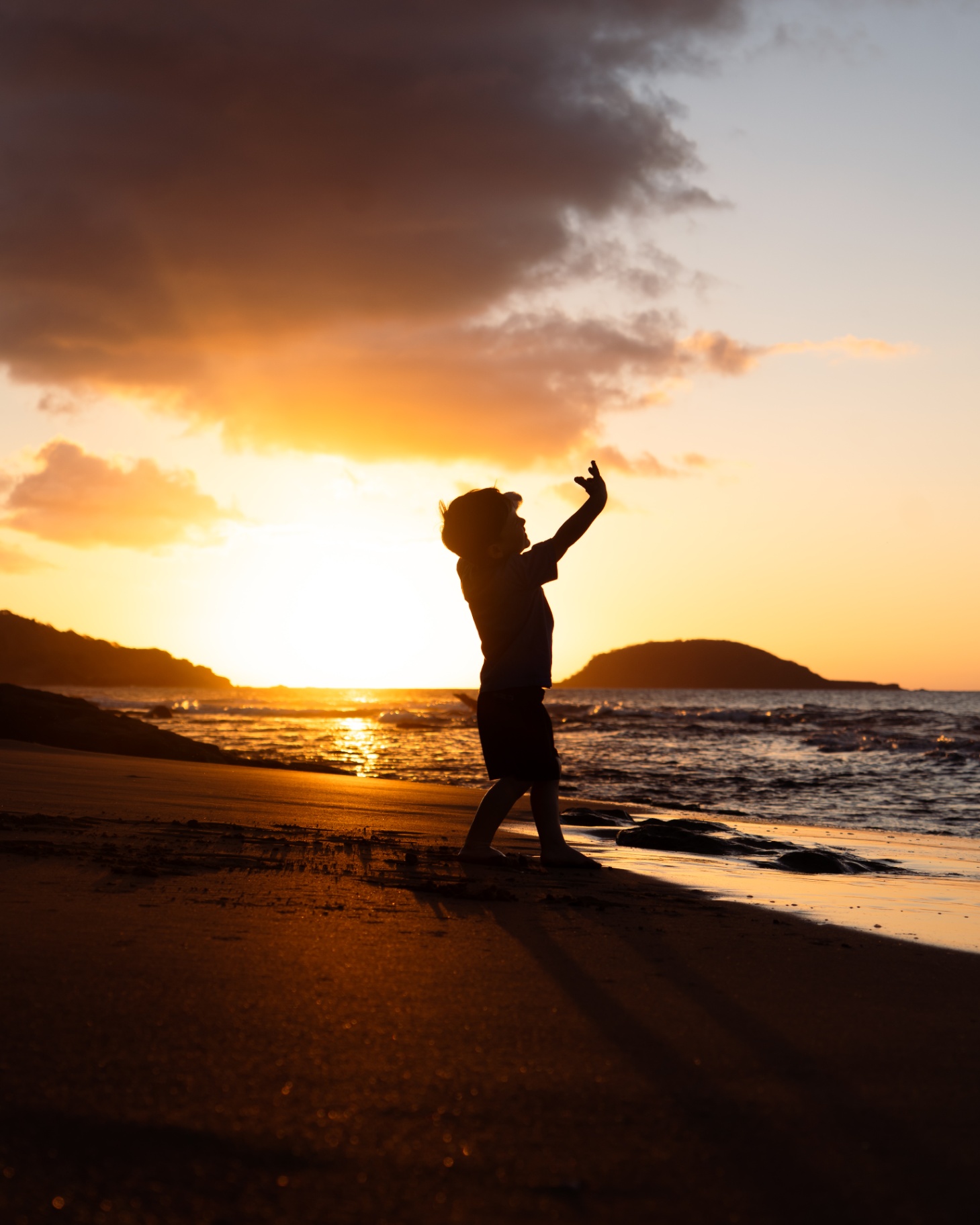 Silhouette d'un enfant sur une plage au coucher du soleil