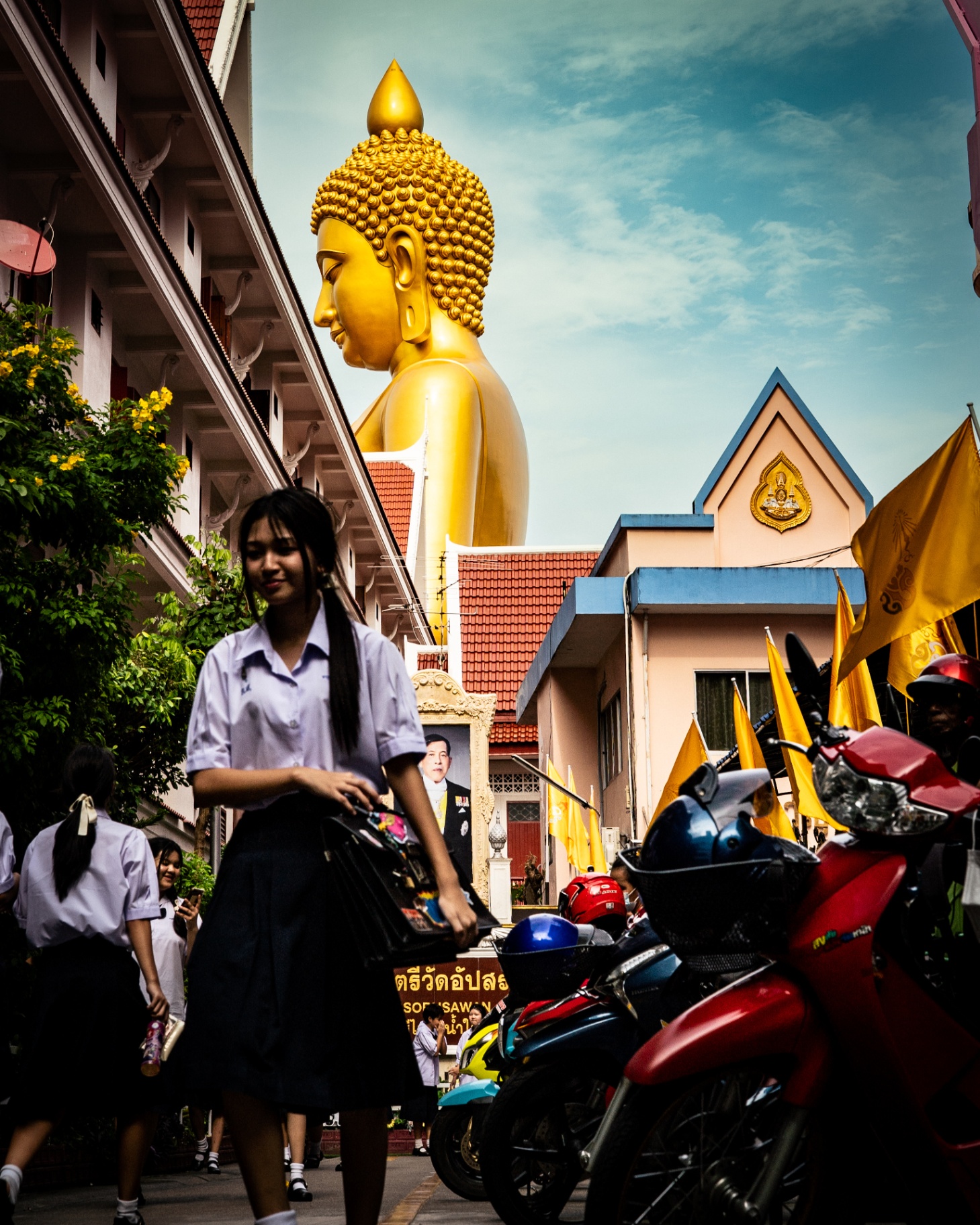Rue colorée devant un temple et sa statue dorée