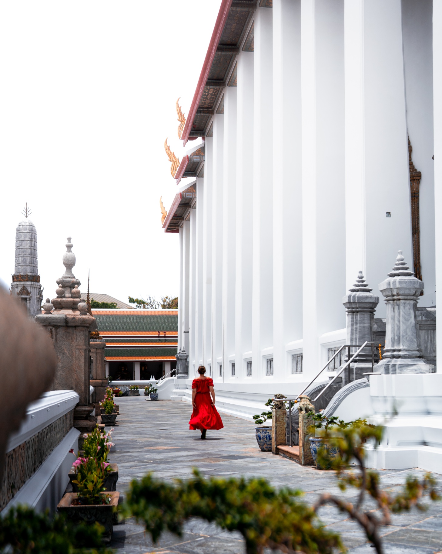 Personne en robe rouge dans l'enceinte blanche d'un temple