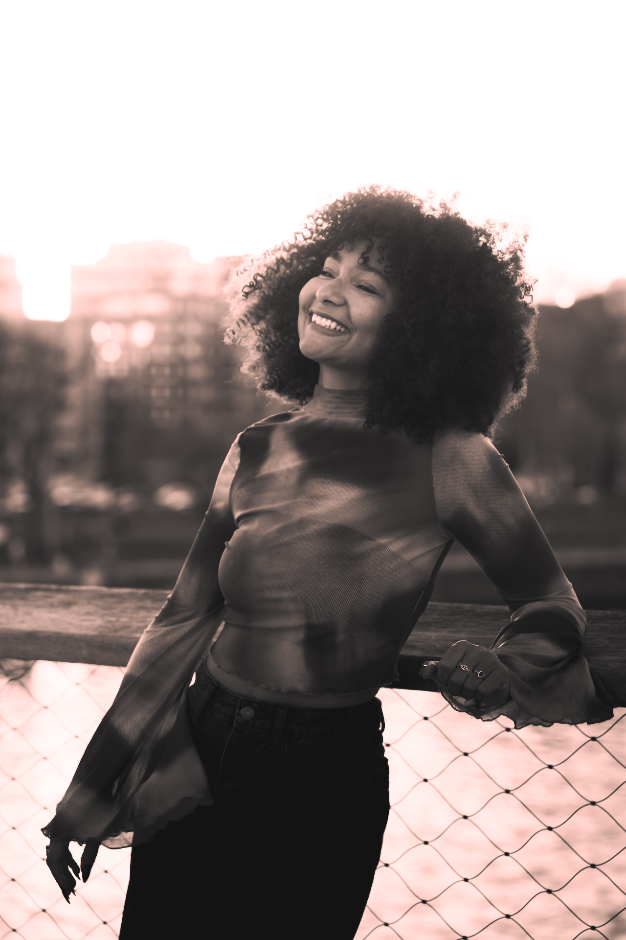 Portrait d'une femme souriante au coucher de soleil, noir et blanc sépia