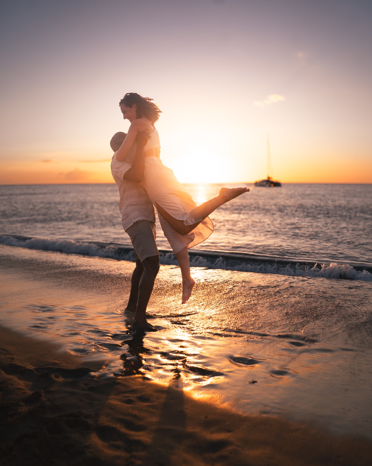 Couple dansant sur la plage au coucher du soleil