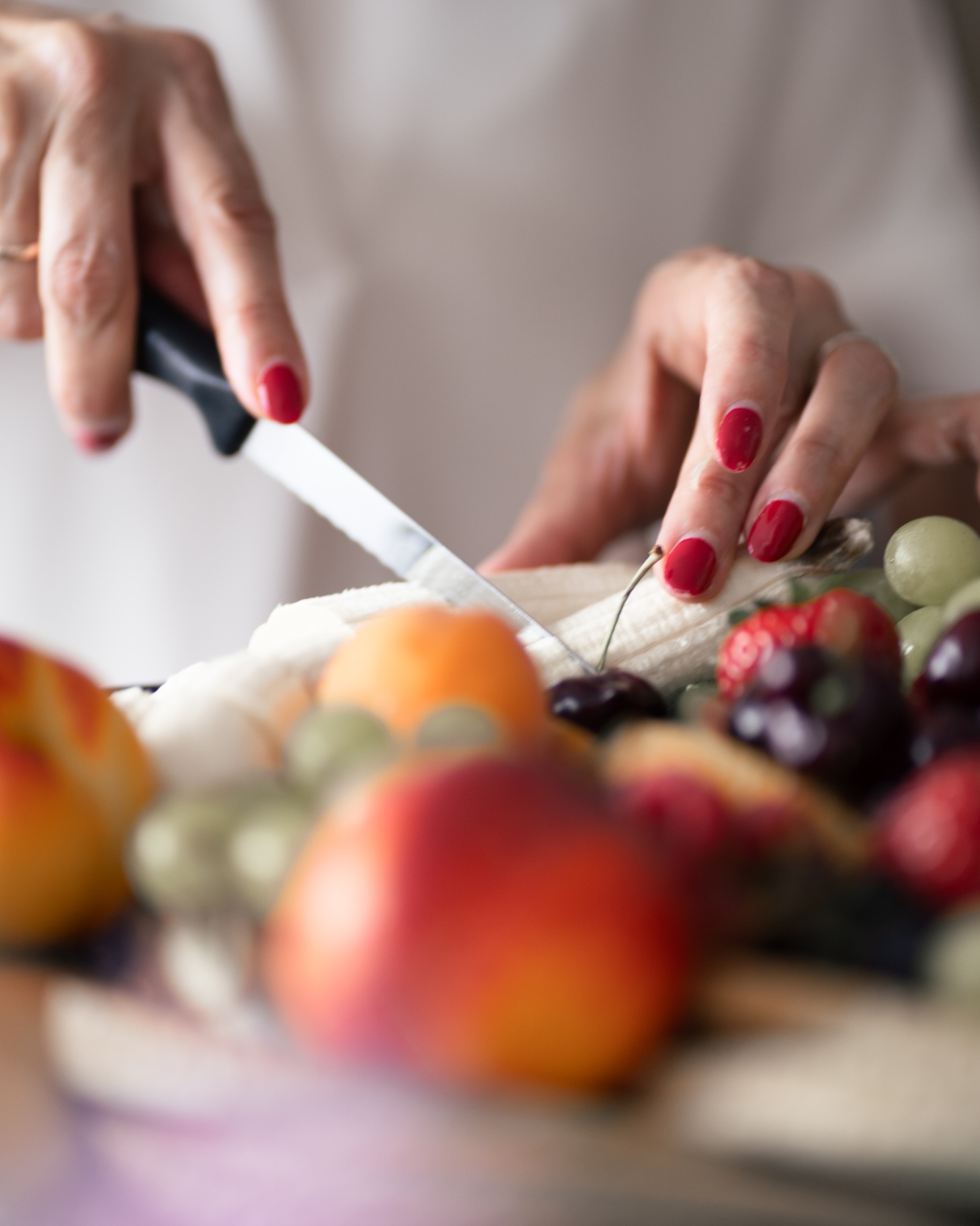 Mains découpant un gâteau de fruits lors d'une réception