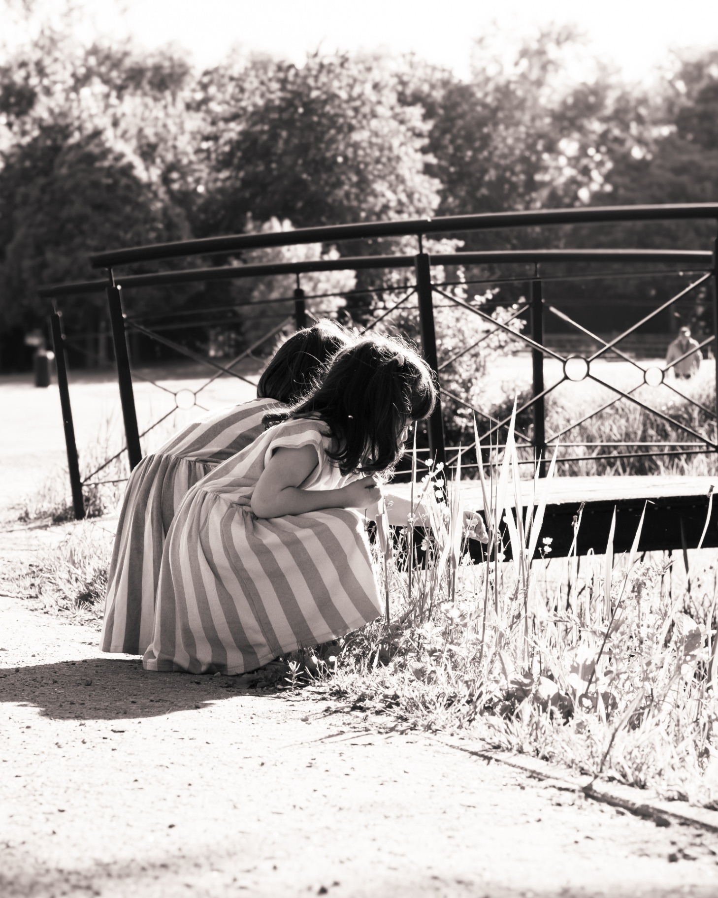 Deux petites filles observant les fleurs au bord de l'eau