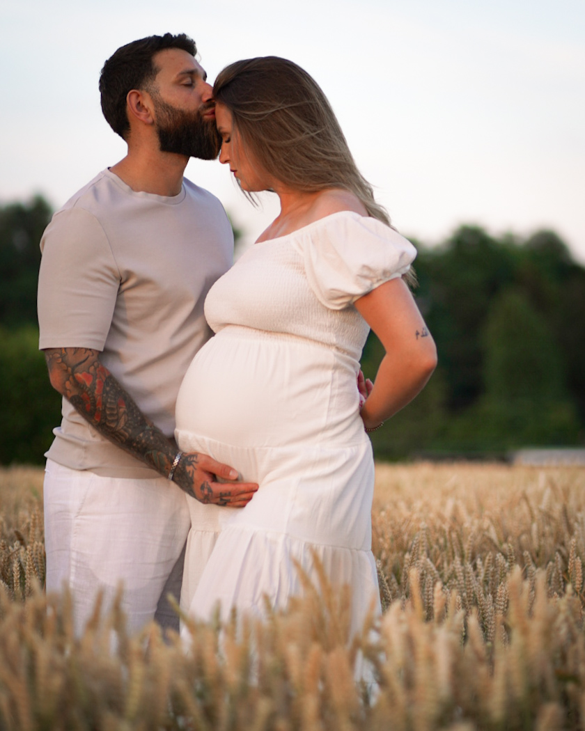 Baiser tendre d'un couple en attente de bébé