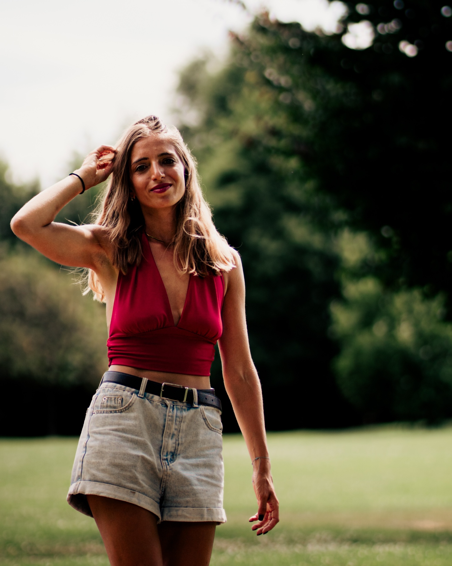 Portrait d'une femme en top rouge dans un parc