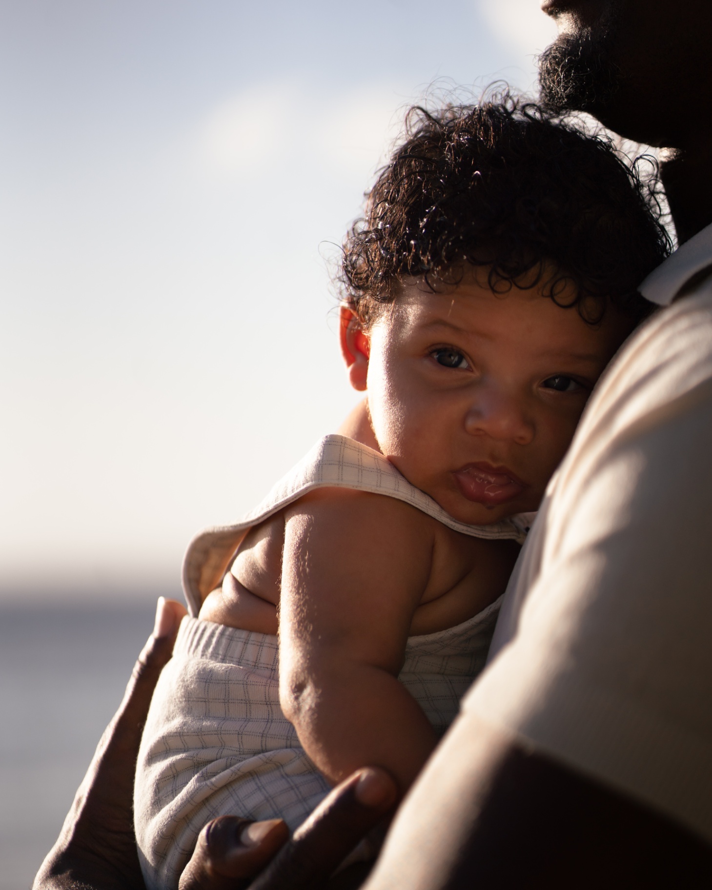 Bébé contre son papa au coucher du soleil