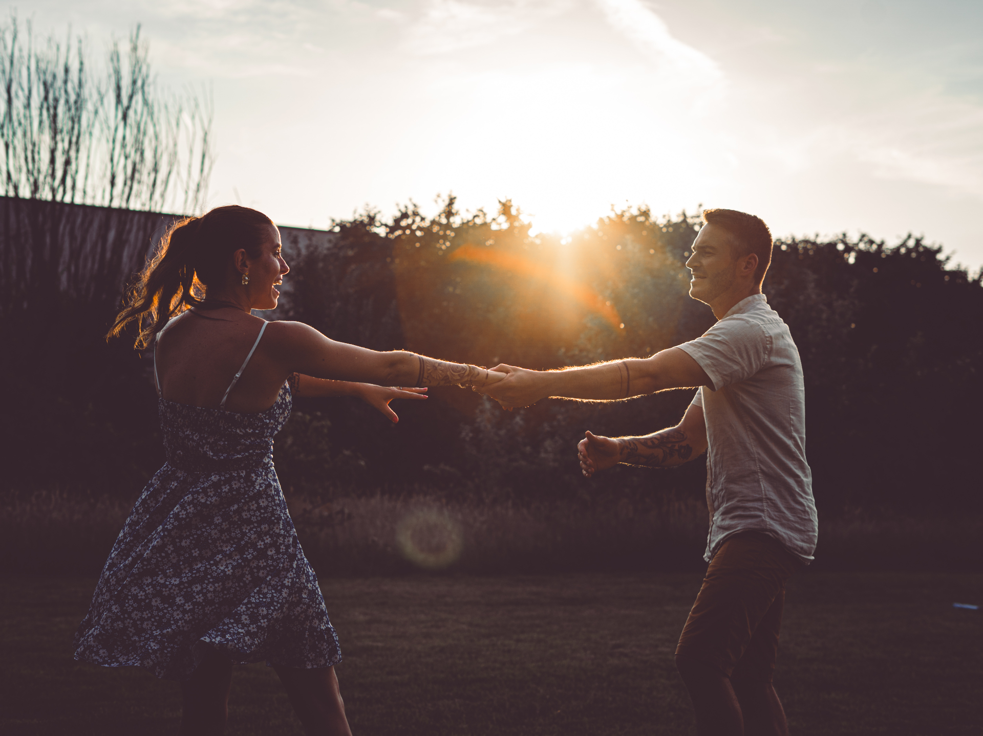 Couple dansant à contre-jour au coucher du soleil